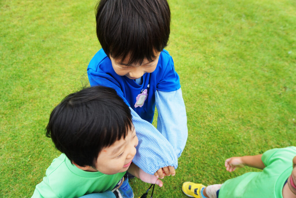 手をつないで笑っている男児たち
