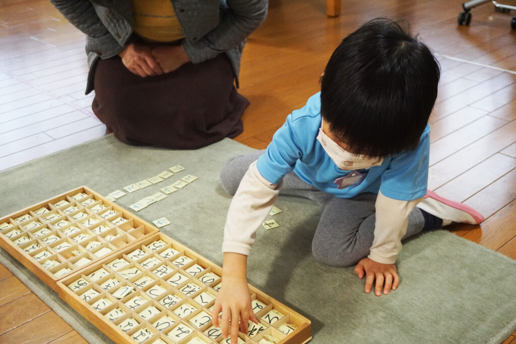 移動50音のお仕事をする男児とモンテッソーリ教師