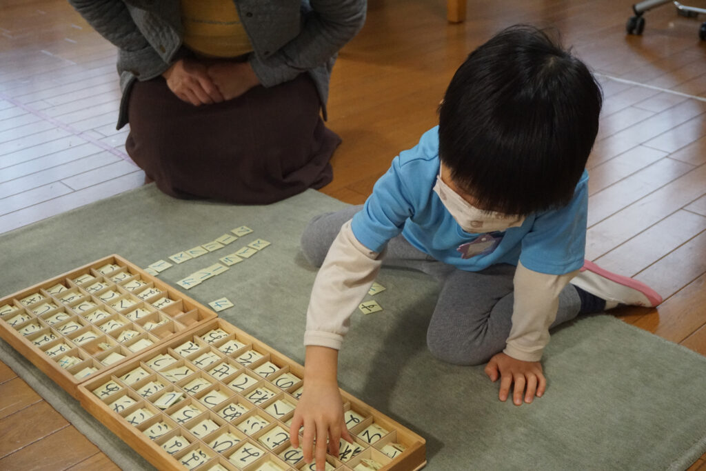 移動五十音のお仕事をする園児とモンテッソーリ教師